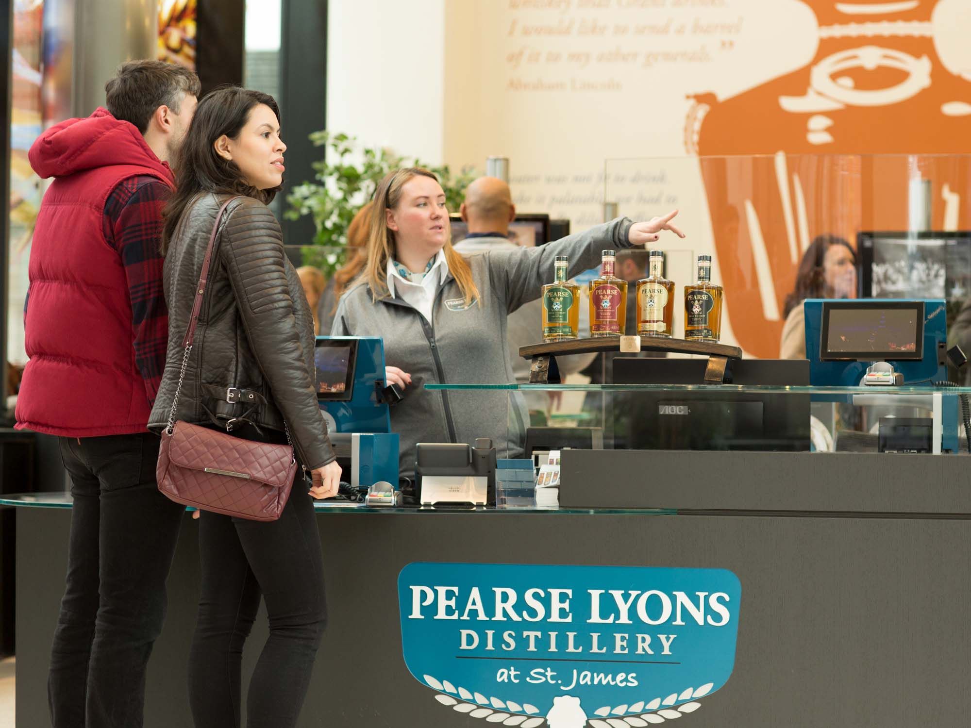 Woman and man being shown where to go at the Pearse Lyons Age Check